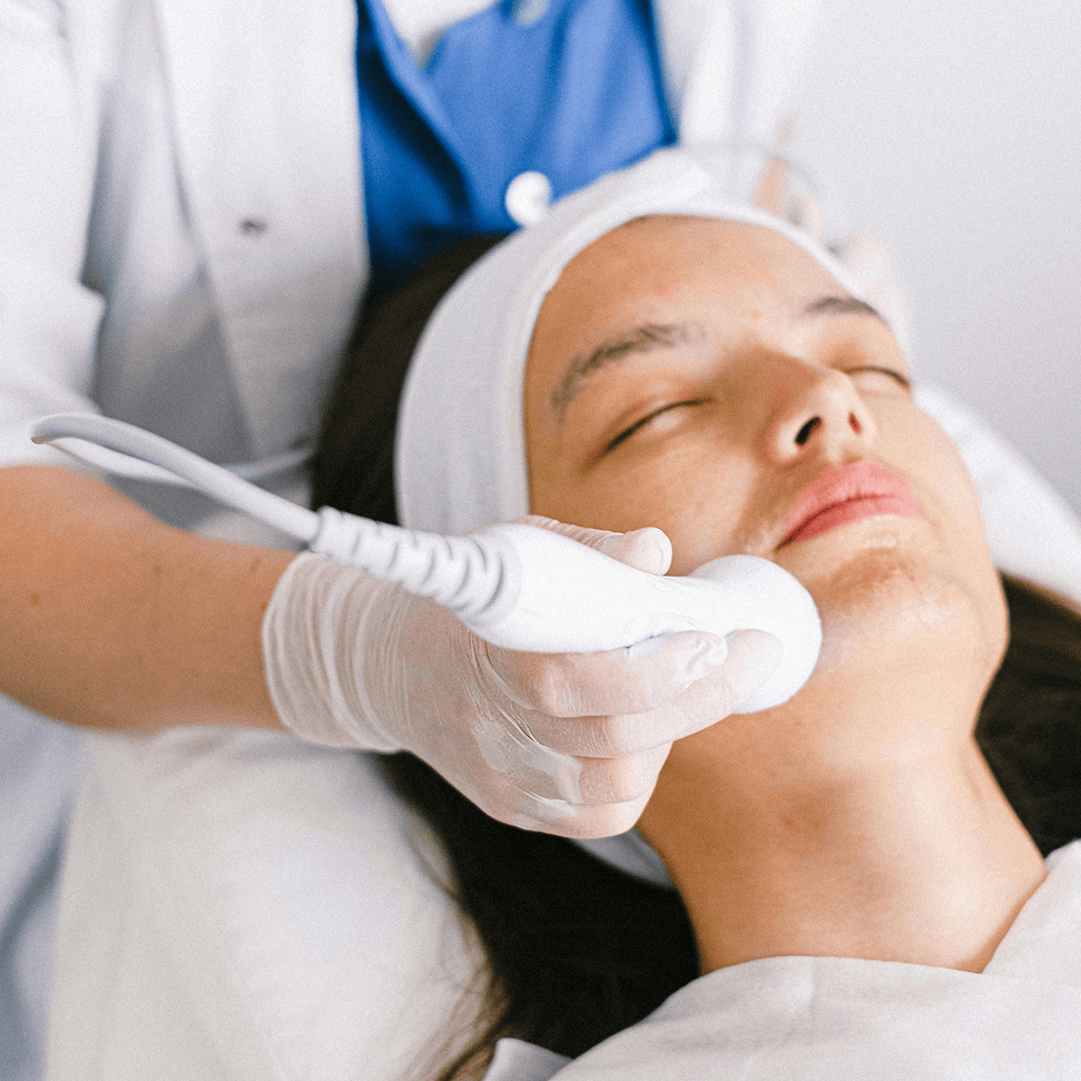 Aesthetician applying a radio frequency RF facial device to stimulate collagen and tighten skin.